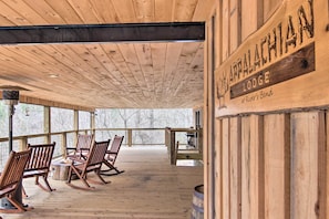 Eine Holzterrasse mit Schaukelstühlen und einem Feuerkorb, beschriftet mit 'Appalachian Lodge at River Bend'.