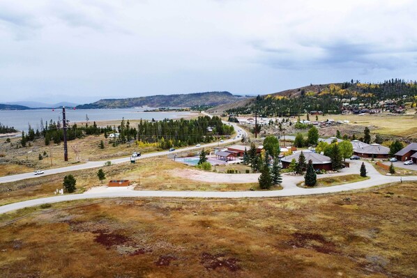A residential area with houses, a road, and a body of water in the background. - Near Lake Granby: Grand Lake Townhome w/ Views (Grand Lake)