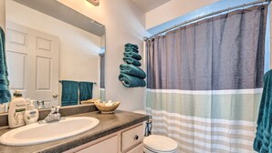 A bathroom with a sink, mirror, and toilet. There are towels stacked on the wall and a striped shower curtain. - Meadow Retreat' Near Parks & USU (Logan)