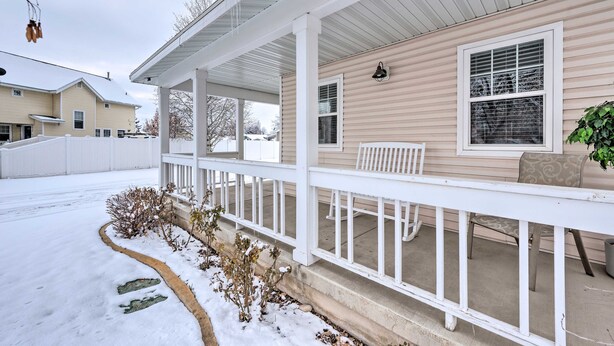 A covered porch with a white railing, a bench, and a potted plant. - Meadow Retreat' Near Parks & USU (Logan)