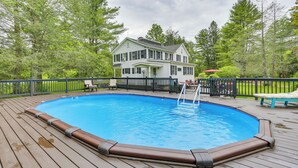 An outdoor swimming pool with a wooden deck, surrounded by a wooden fence and trees. - Game Room & Yard: Greentown Home Near State Park (Greentown)