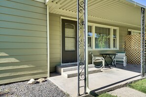 A house with a porch, a door, a window, and a table with chairs. - Fruita Vacation Rental: Walk to Downtown! (Fruita)