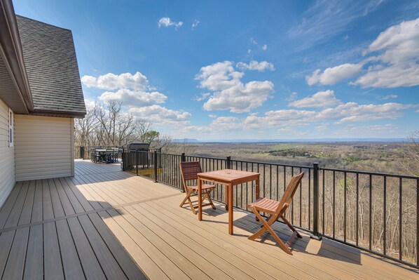 Eine HolzdTerrasse mit Tisch und Stühlen, die einen schönen Panoramablick bietet.