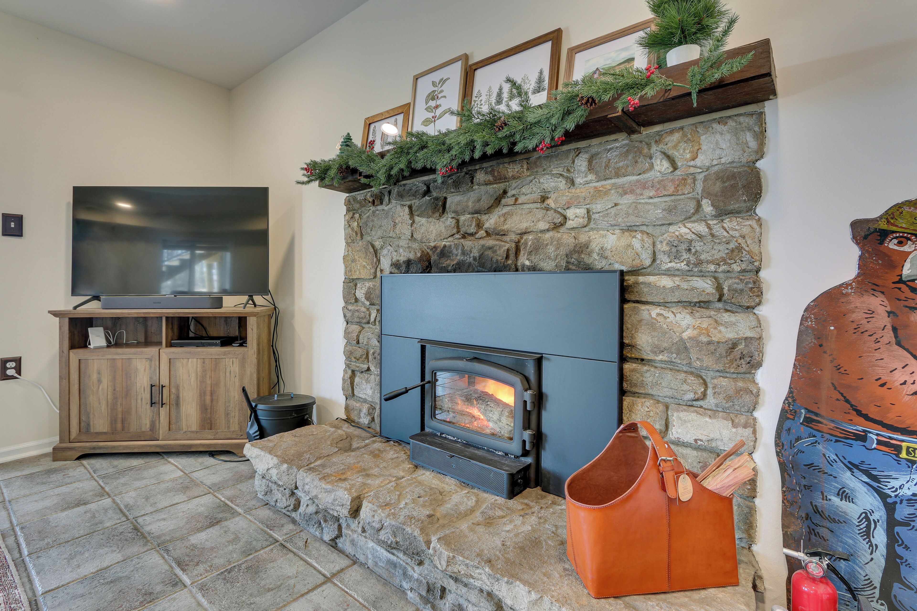 A stone fireplace with a modern TV and a decorative mantelpiece.