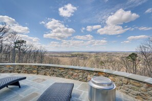 A stone patio with a view of a mountainous landscape.