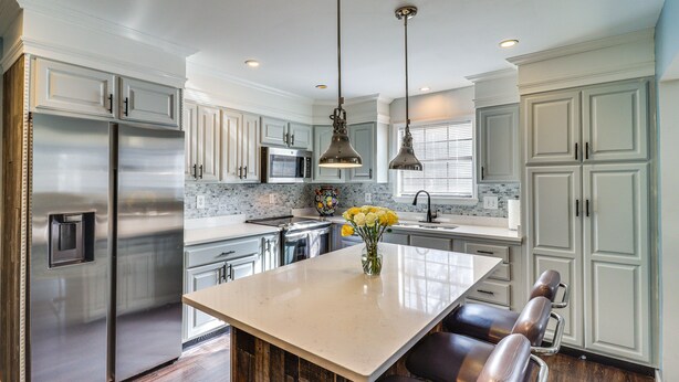 A modern kitchen with stainless steel appliances, a marble island, and pendant lighting. - 'house in the Woods' in Ooltewah w/ Fire Pit! (Ooltewah)