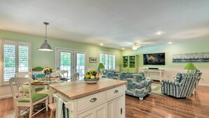 A spacious living area with a wooden dining table, green cushioned chairs, a blue patterned sofa, and a green armchair. - Lake Norman Retreat w/ Dock ~ 1 Mi to Marina! (Mooresville)