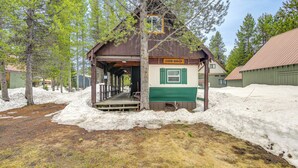 A rustic cabin with a porch, surrounded by snow and trees. - Cozy Island Park Getaway By ATV Trails & Reservoir (Island Park)