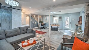 A modern living room with a grey sofa, coffee table, and a fireplace. - Sauna & Game Room: Lake House in Locust Grove! (Locust Grove)