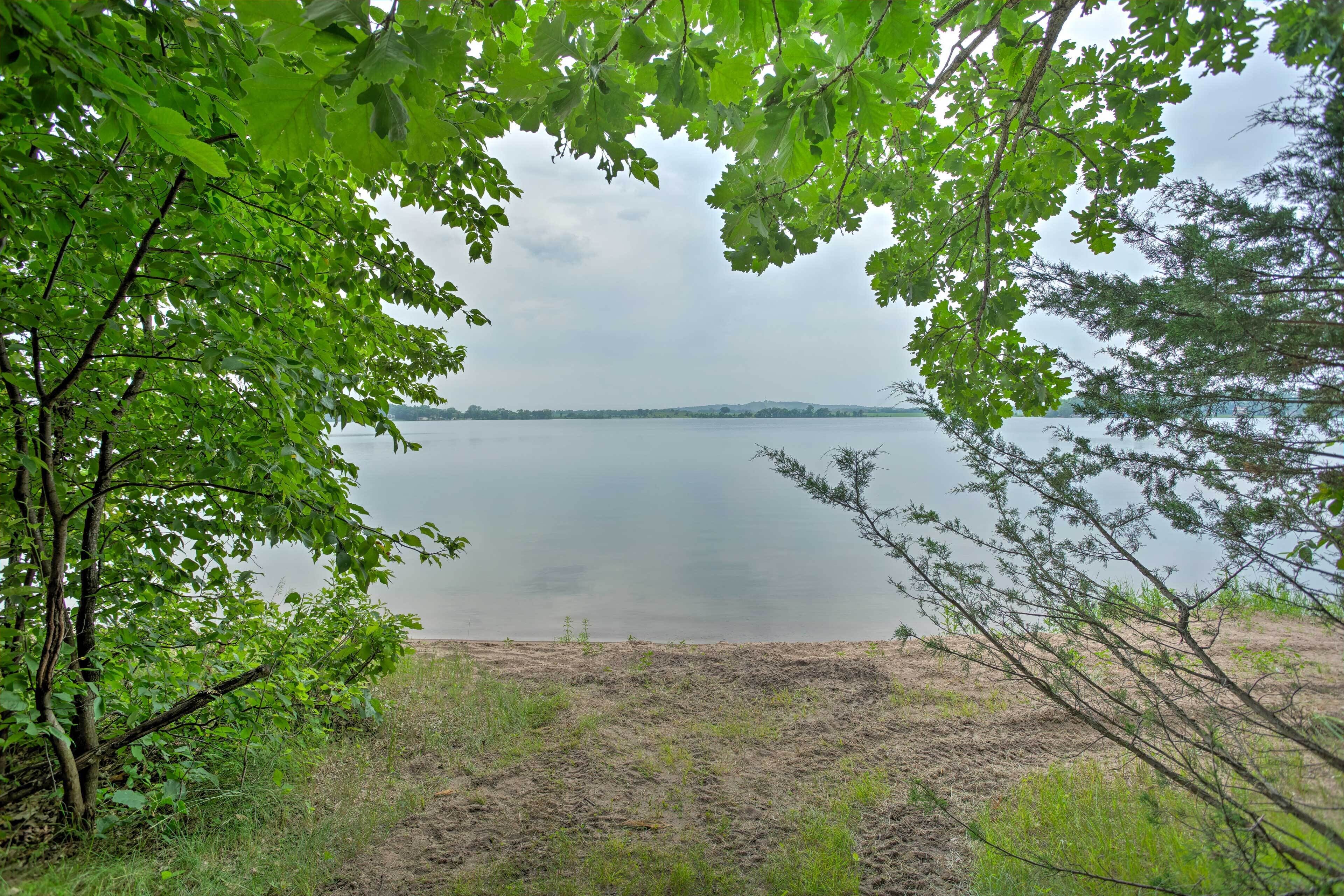 A natural landscape with a body of water, trees, and a grassy area.