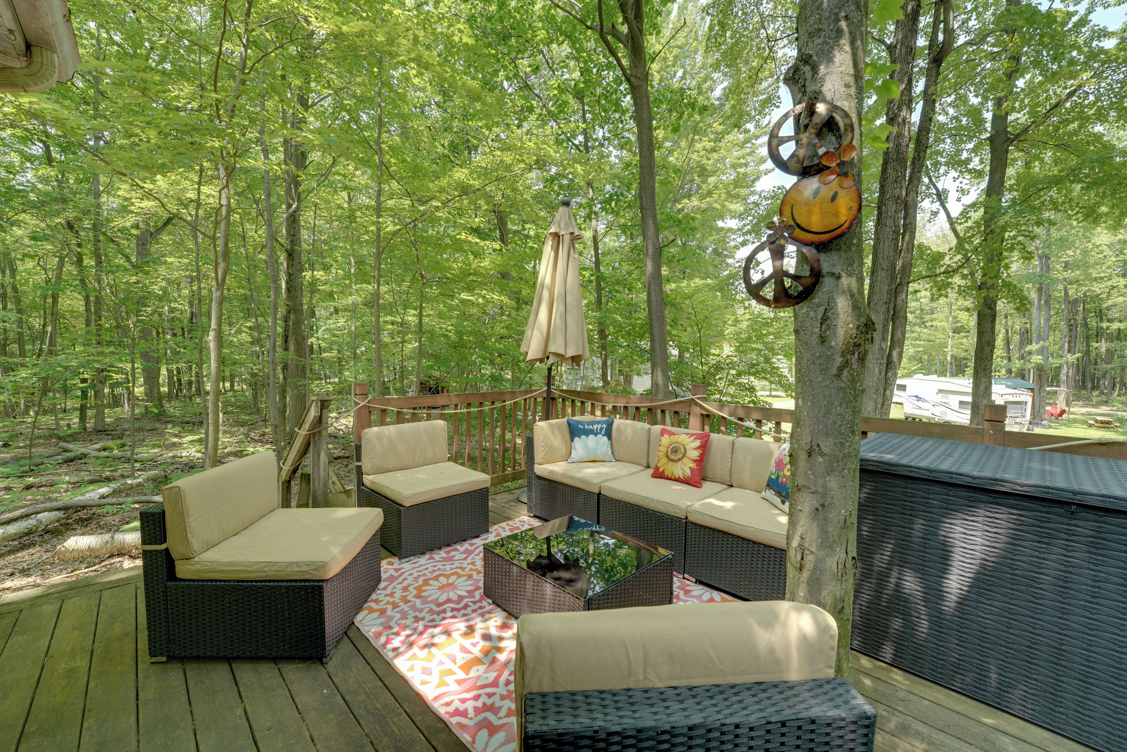 An outdoor deck with wicker furniture, a patterned rug, and a hammock.