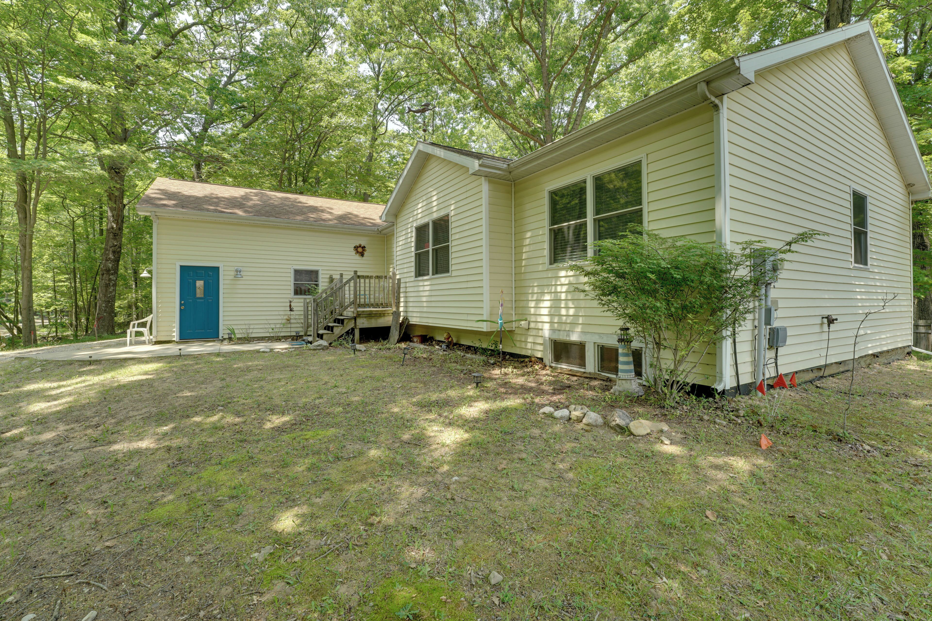 A two-story house with a front porch and a small deck.