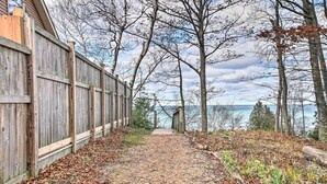 Un sentier en bois mène à une structure également en bois, d’où l’on a une vue sur l’eau.