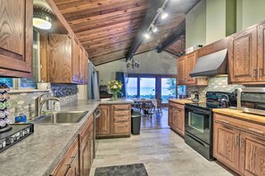 A spacious kitchen with wooden cabinets, a large island, and a view to the outside. - Lakefront Forestville Paradise w/ Private Beach! (Forestville)