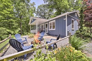 A house with a covered porch, outdoor seating, and a fire pit.