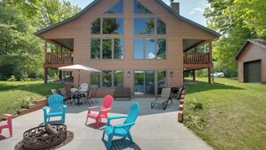 A two-story house with a covered patio area, outdoor seating, and a fire pit. - Lakefront Cottage in Iron River: 3 Mi to Skiing! (Iron River)