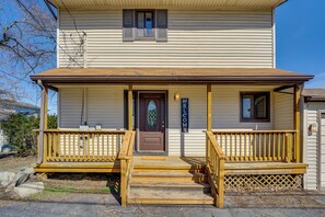 A two-story house with a front porch, a brown door, and a welcome sign. - Spacious Lakefront Home in White Lake (White Lake)