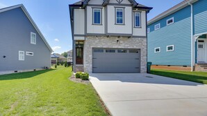 A two-story house with a stone facade, a garage, and a well-maintained lawn.