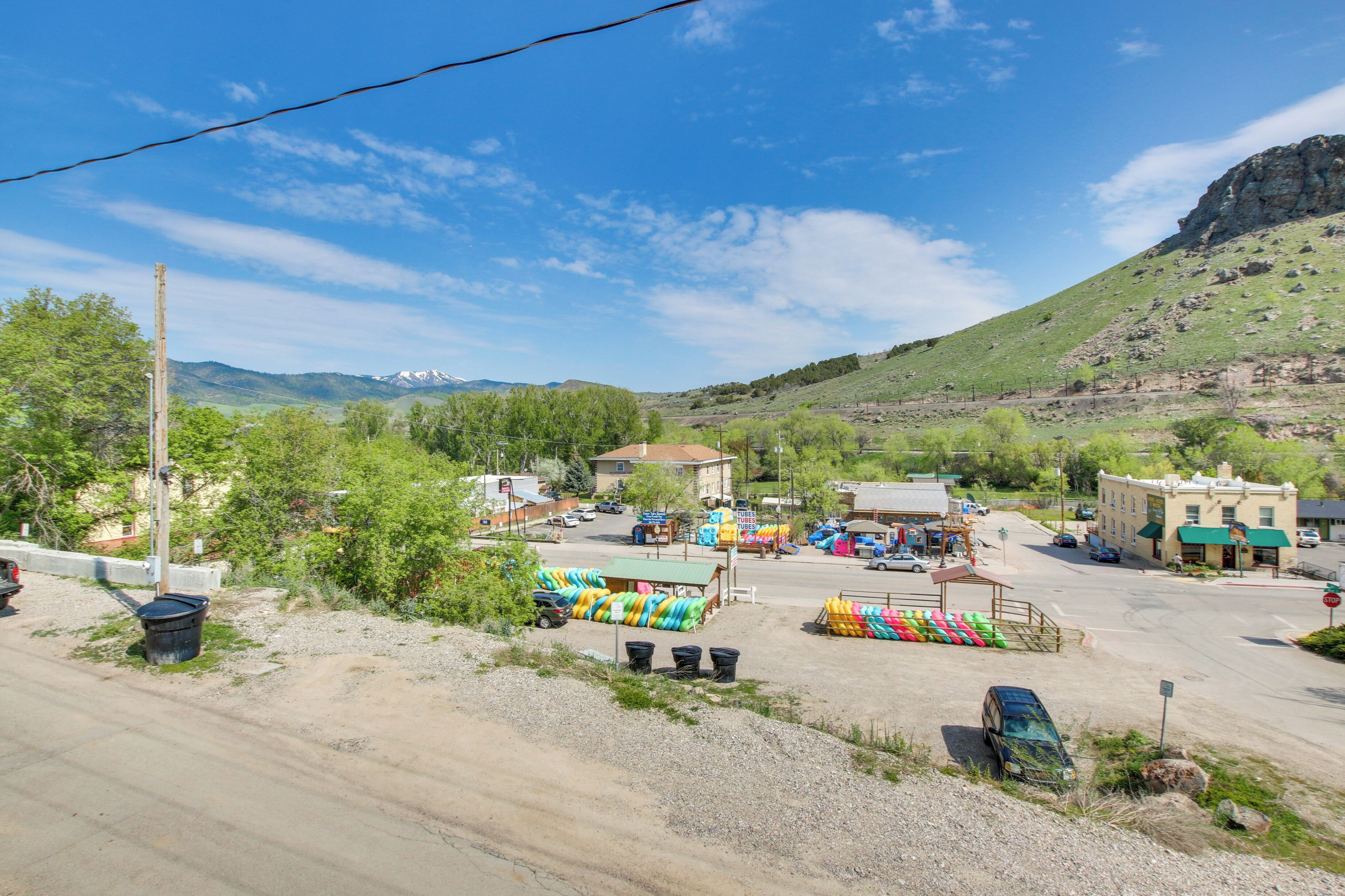 A parking lot with a dirt road, a small building, and a mountain in the background.