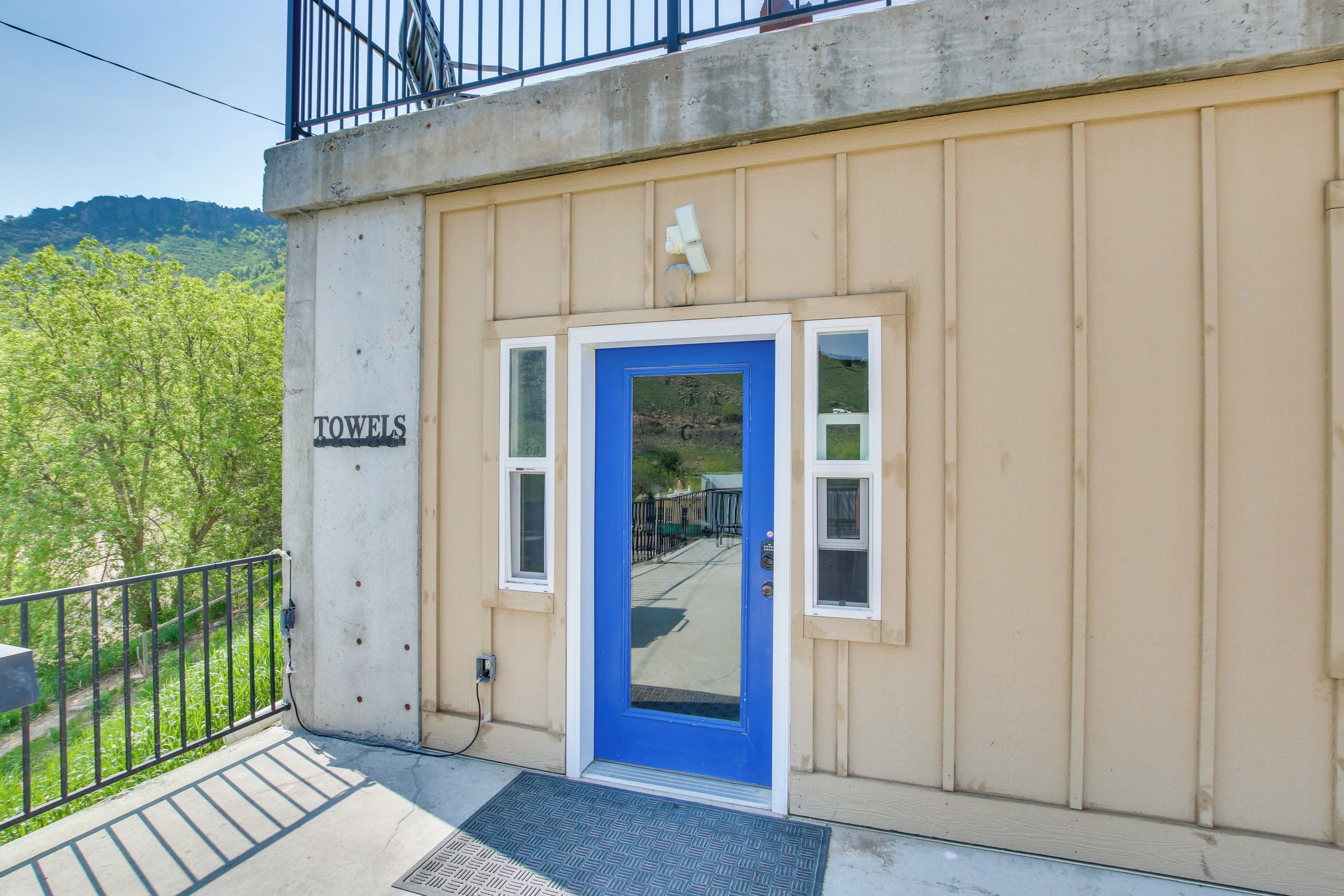 A building with a blue door, a sign reading "TOWELS", and a view of a green landscape.