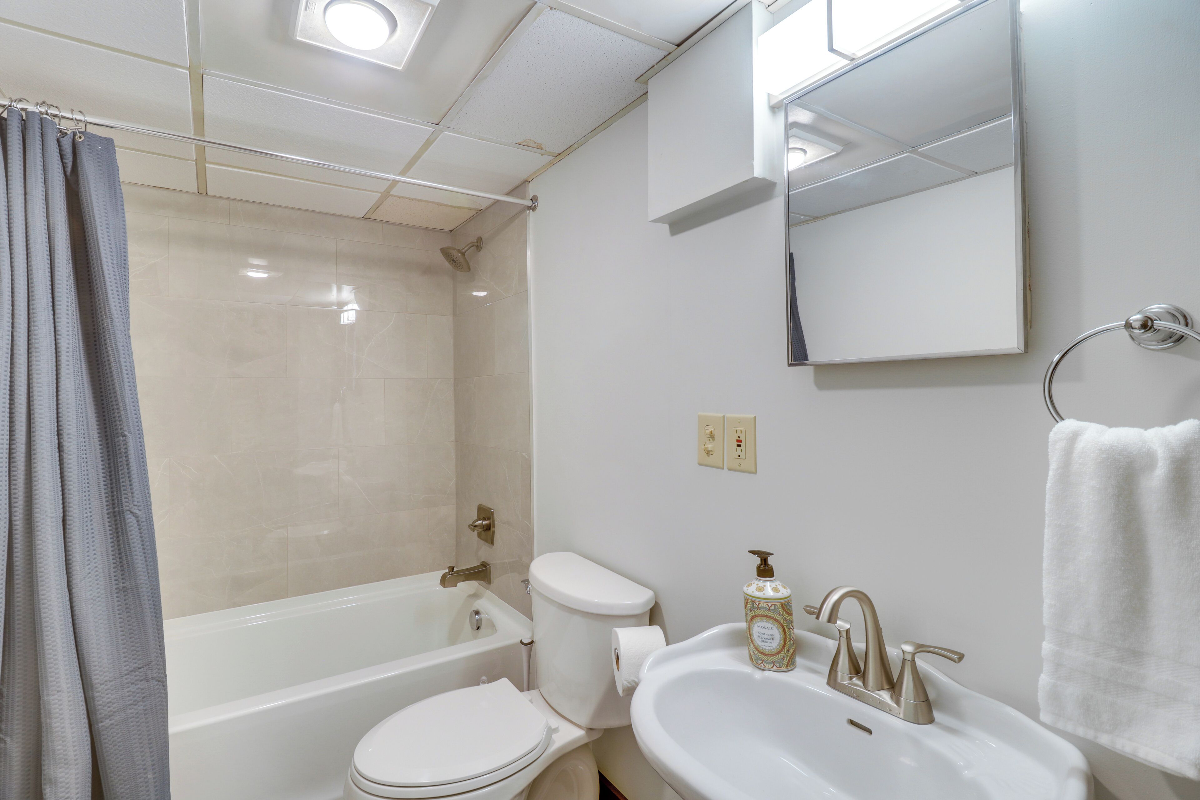 Une salle de bain avec une baignoire, des toilettes, un lavabo et un miroir.