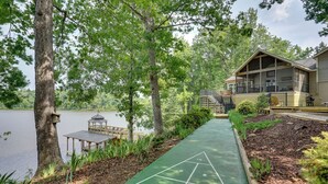 A lakeside property with a shuffleboard court, wooden deck, and a gazebo. - Lakefront Vacation Rental w/ Views & Hot Tub! (Bracey)