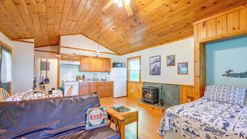 A cozy cabin interior with a dining area, kitchen, and a fireplace.