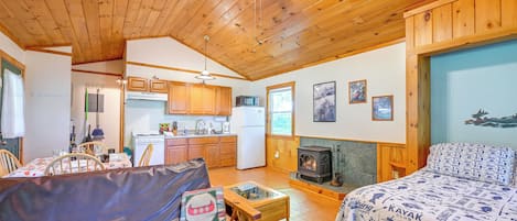 Un intérieur de chalet chaleureux comprenant un coin repas, une cuisine et une cheminée.