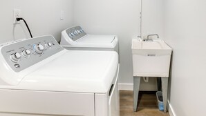 Une buanderie équipée de deux machines à laver et d’un évier.