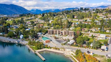 A coastal town with residential buildings, a marina, and mountains in the background.
