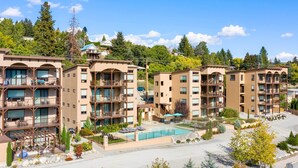 Un hôtel à plusieurs étages doté de balcons, d’une piscine et d’un jardin aménagé.