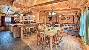 Un'ampia baita di legno con una grande sala da pranzo, cucina e zona relax.
