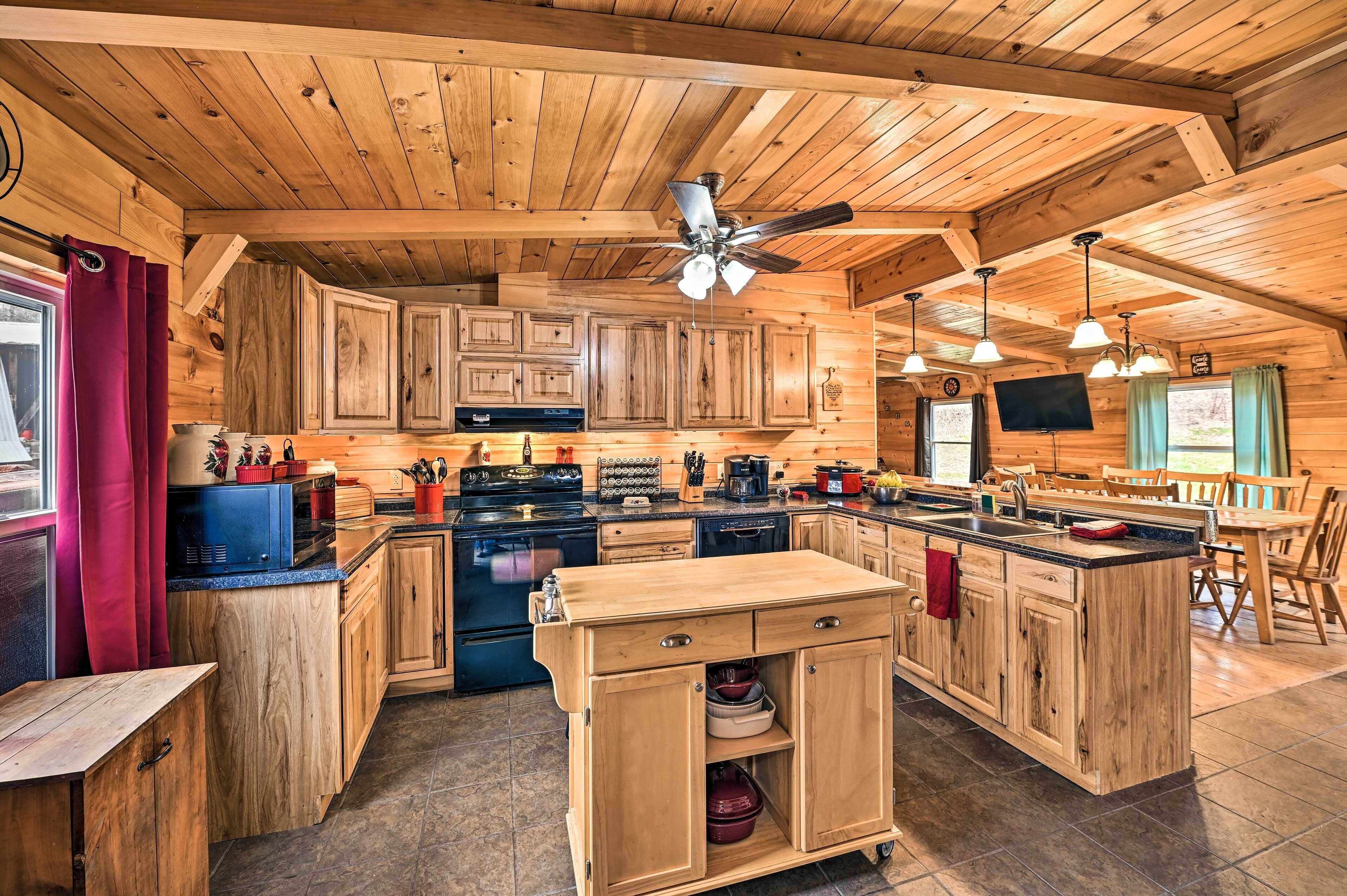 A spacious kitchen with wooden cabinets, a central island, and a ceiling fan.