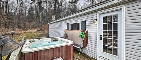 Una terraza de madera con un jacuzzi y un banco de madera.