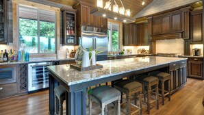 A spacious kitchen with a large island, stainless steel appliances, and wooden cabinetry. - Luxurious Waterfront Retreat w/ Private Pond! (Ridgefield)
