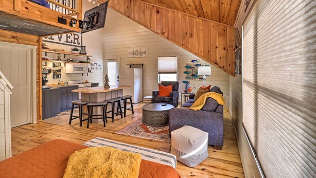 Un espace de vie chaleureux de style loft comprenant une cuisine, un coin repas et un espace salon.