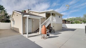 Une maison à deux étages dotée d’un patio couvert, d’une cheminée et d’un escalier menant à l’étage supérieur.