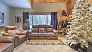 A cozy living room with a leather sofa, a white Christmas tree, and a wooden ceiling. - Phelps Cabin on 26 Acres w/ Fire Pit! (Phelps)