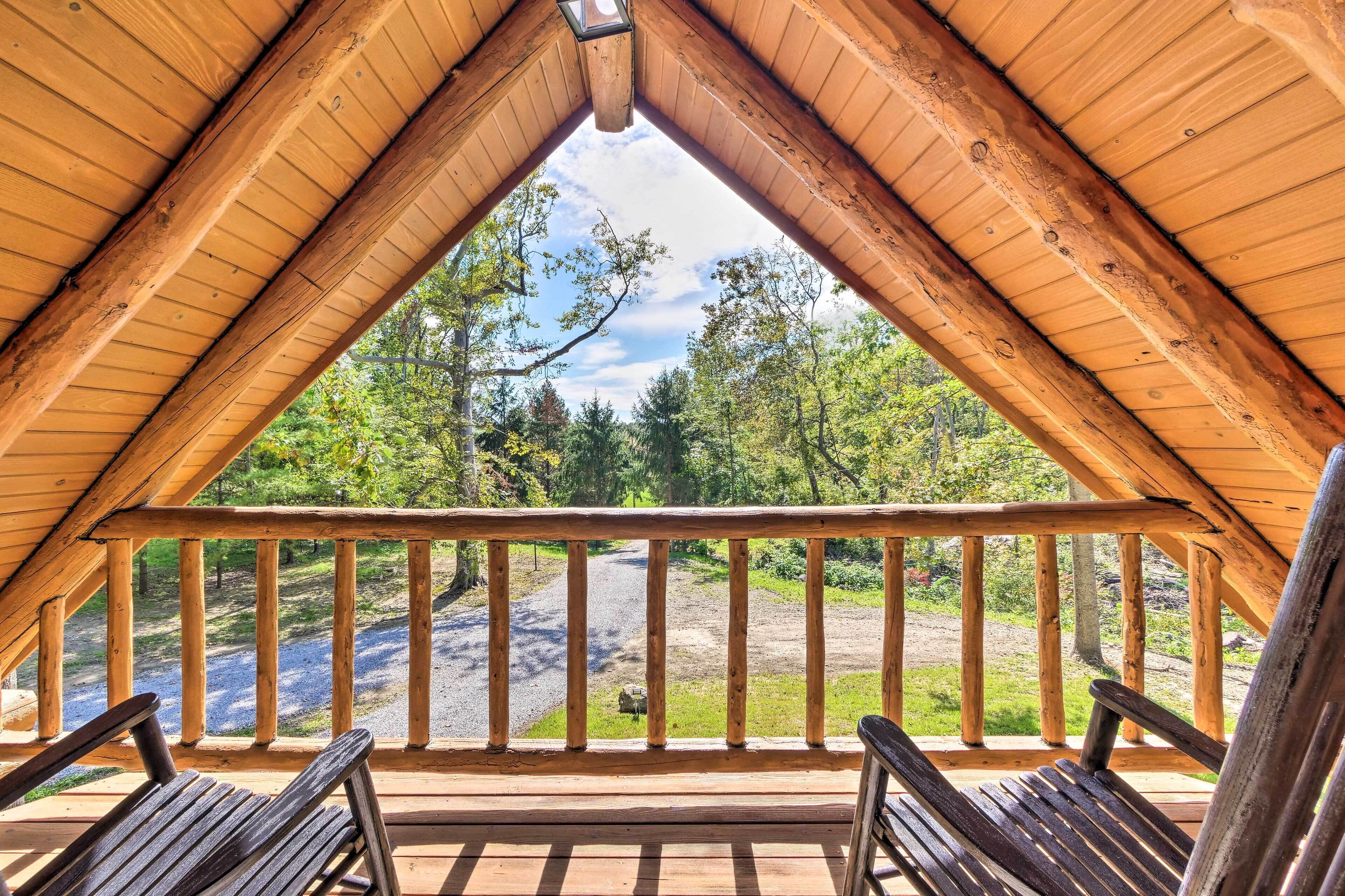 Une pièce aménagée sous les combles, avec un plafond en bois et une vue sur une zone boisée.