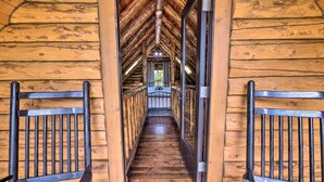 Un escalier en bois avec une rampe métallique menant à une pièce dotée d’une fenêtre.