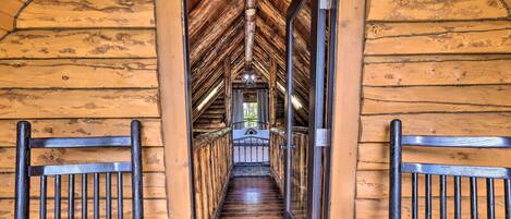 Una escalera de madera con barandilla de metal que conduce a una habitación con ventana.