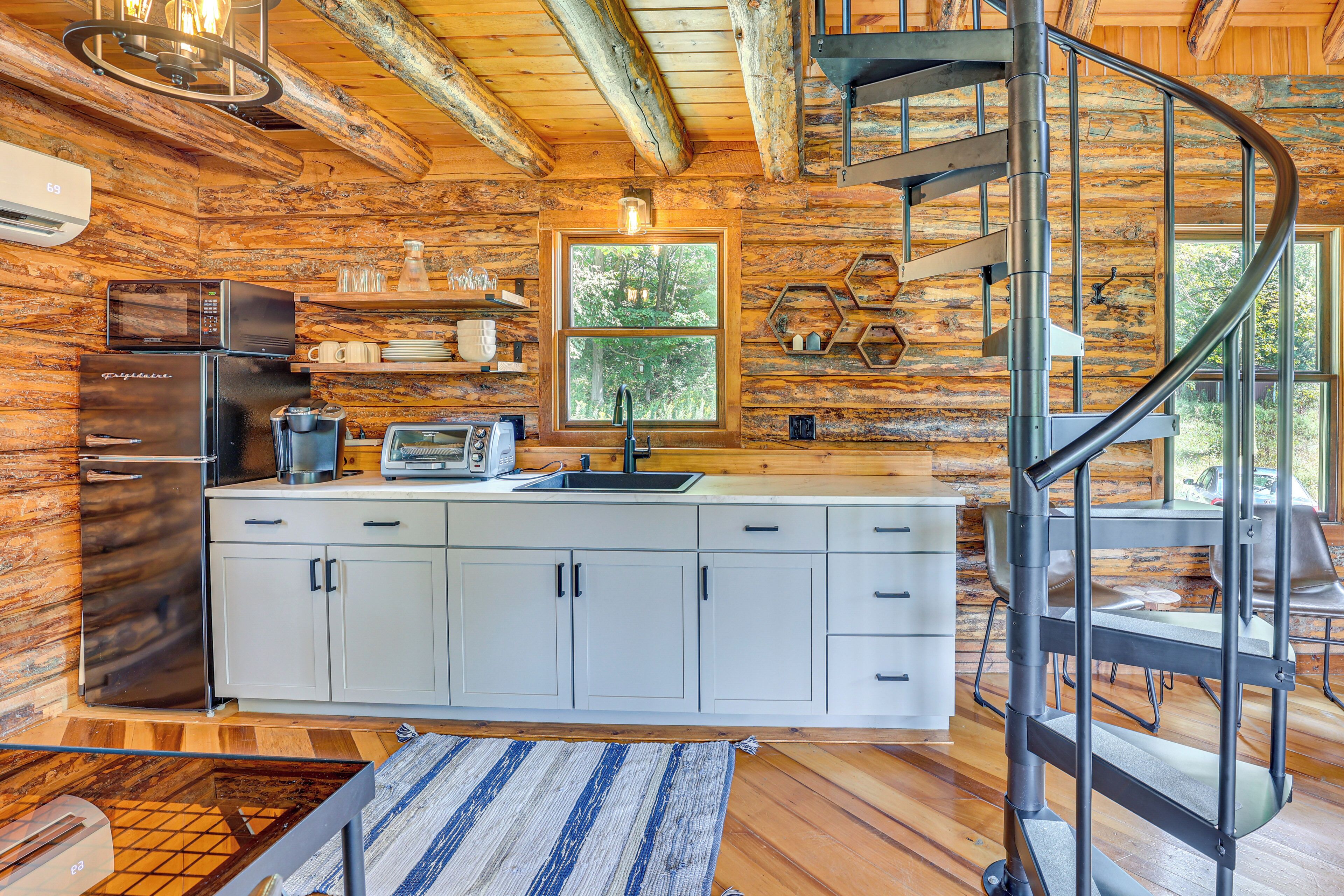 A log cabin kitchen with a central island, a built-in microwave, and a stainless steel refrigerator.