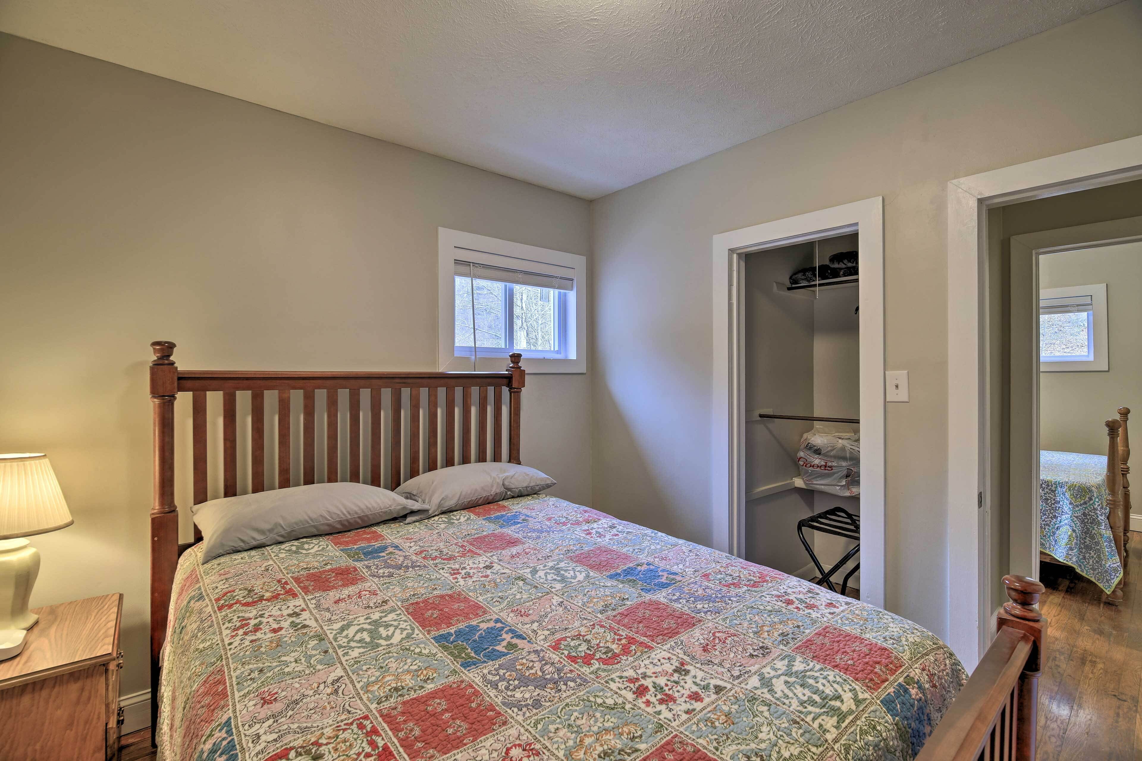 A bedroom with a wooden bed, a nightstand, a window, and a closet.