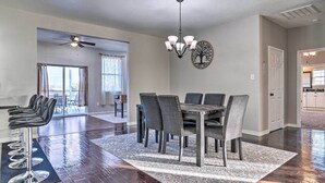 Un comedor con candelabro, una mesa de comedor con sillas y un taburete de bar.