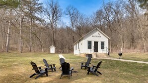 A house named 'Meadowvale' with a front porch, a pathway leading to the entrance, and three Adirondack chairs in the yard. - Pet-friendly Blue Mounds Vacation Rental w/ Yard! (Blue Mounds)