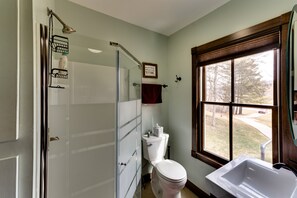 Une salle de bain avec douche, toilettes et lavabo.