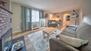 A living room with a fireplace, sofa, coffee table, and a rug. - Meadville Home: Private Yard & Fishing Nearby (Meadville)