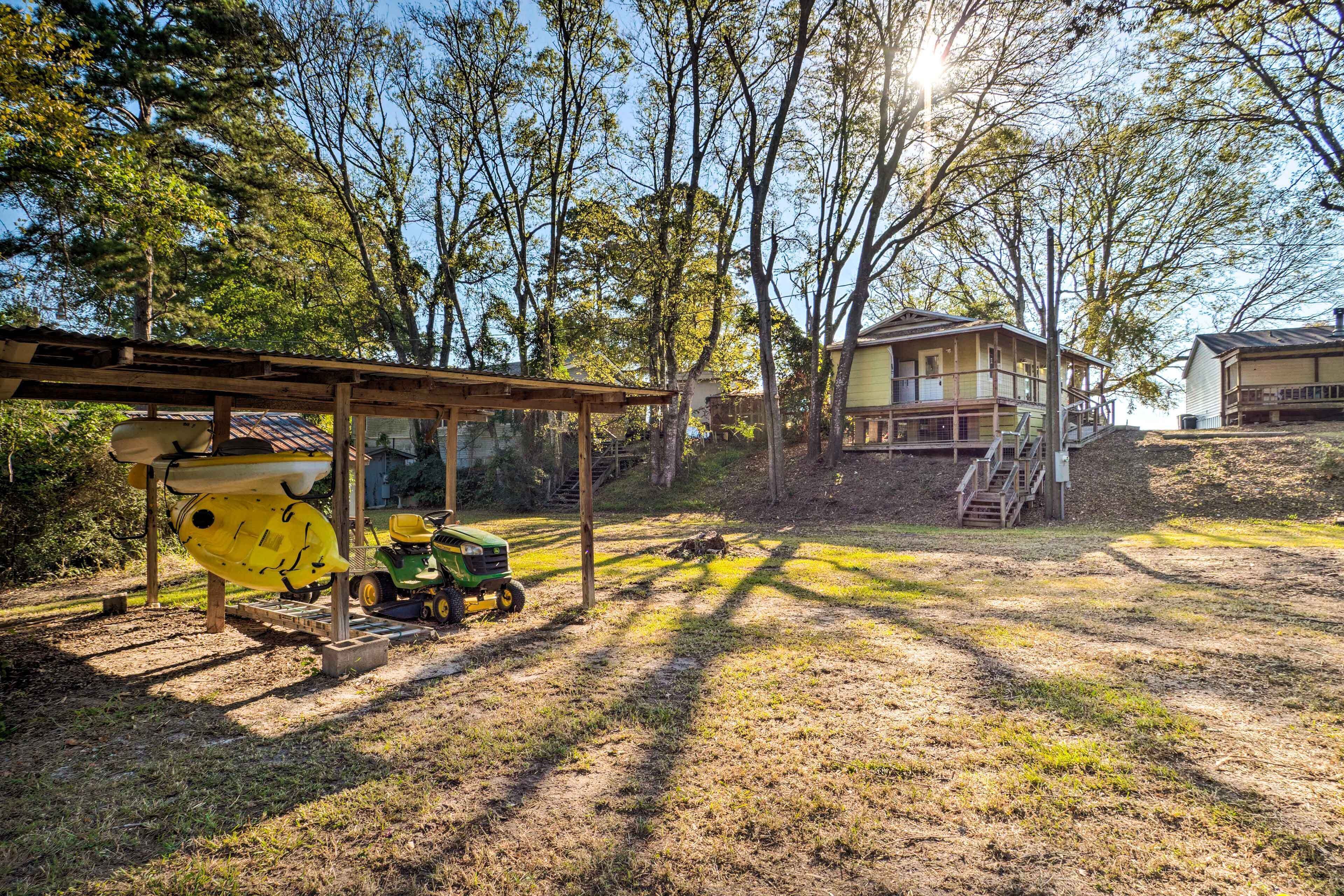 A residential area with a covered outdoor area, a green tractor, and a yellow kayak.