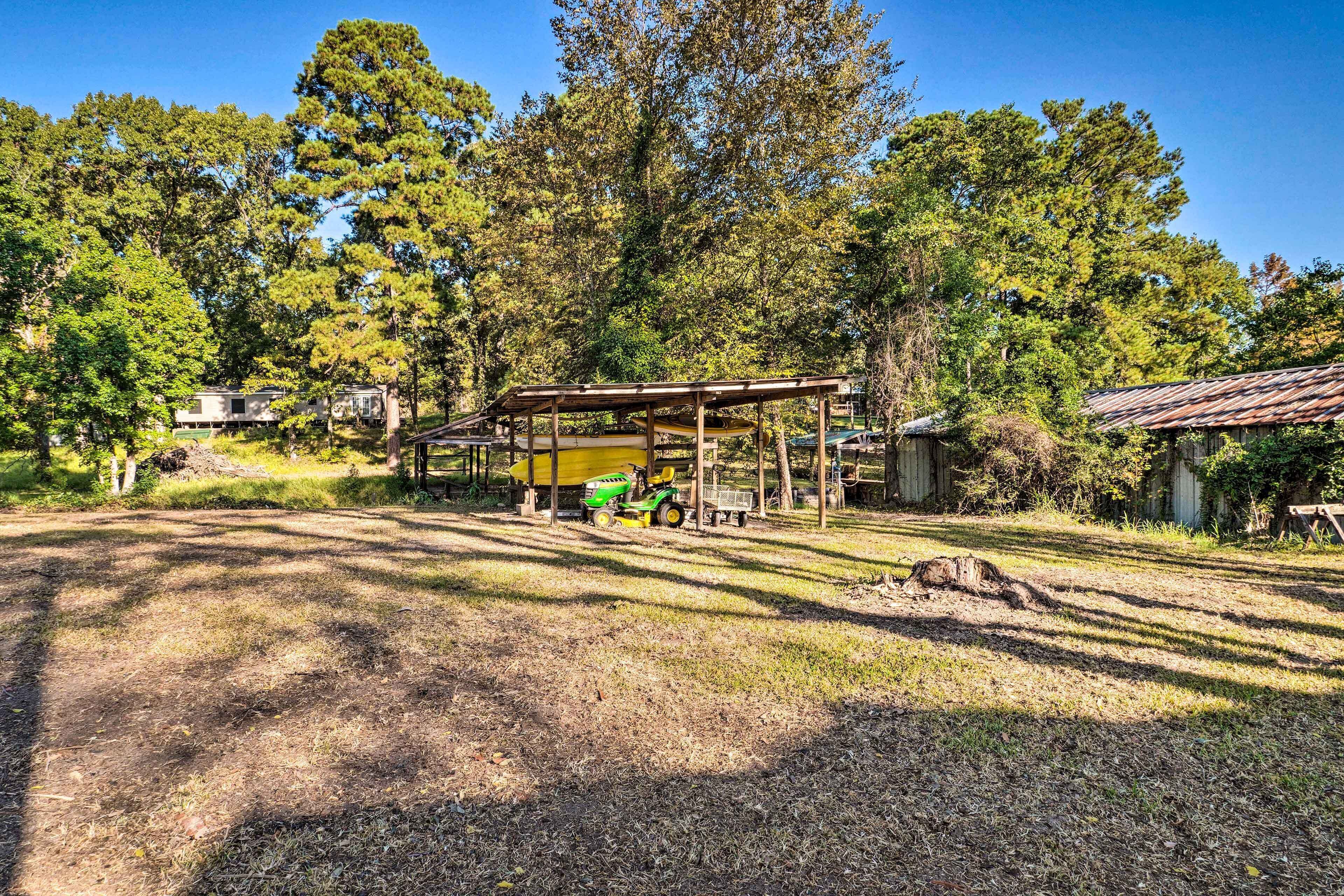 A rustic outdoor area with a covered seating area, a green tractor, and a small shed.