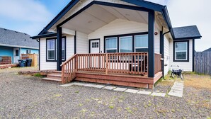 A single-story house with a porch, a wooden deck, and a gravel driveway. - Modern Ocean Shores Home, 2 Mi to Beach! (Ocean Shores)